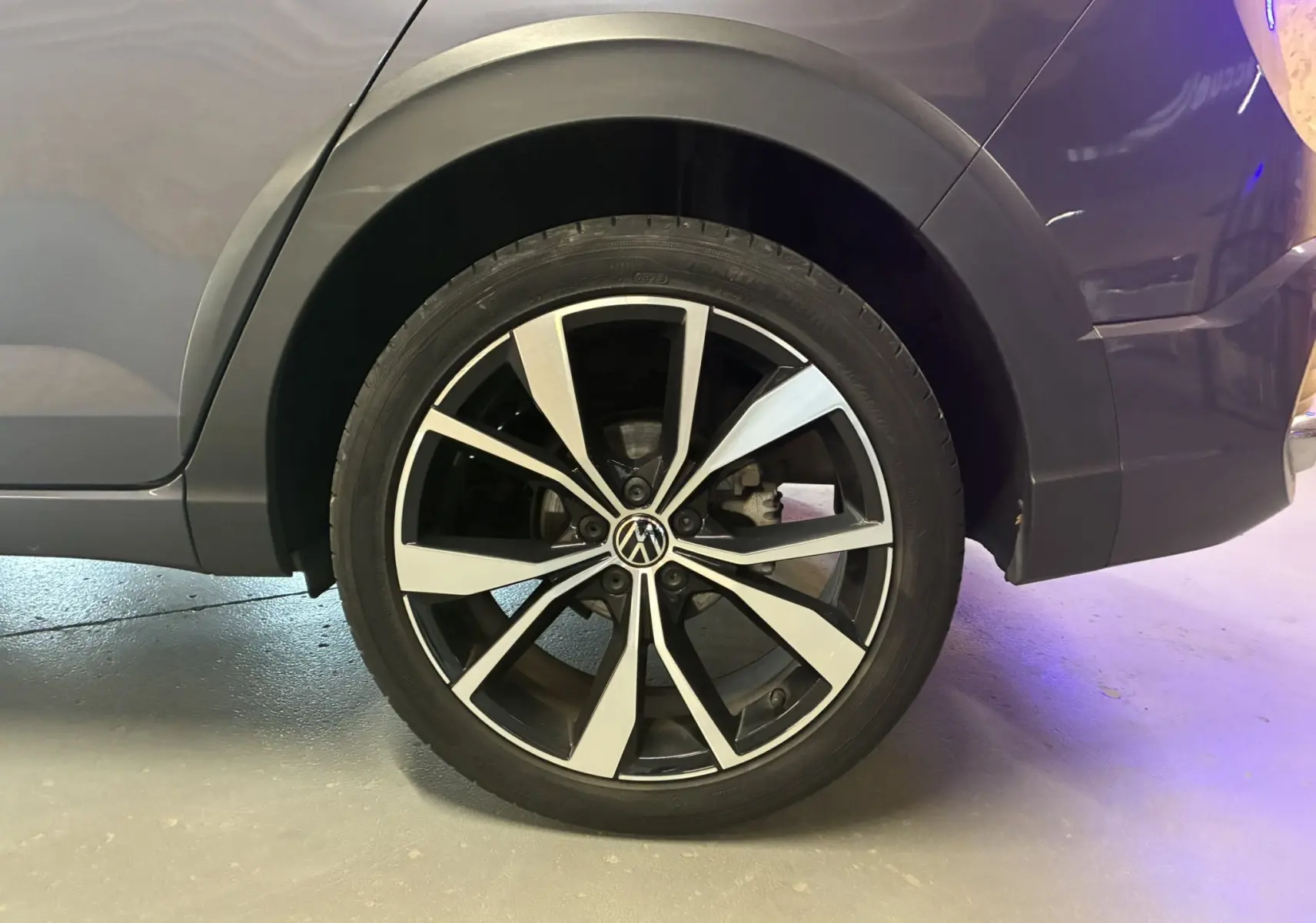 Gros plan sur la roue avant droite du Volkswagen Taigo gris 2023, soulignant la jante alliage bicolore au design moderne.