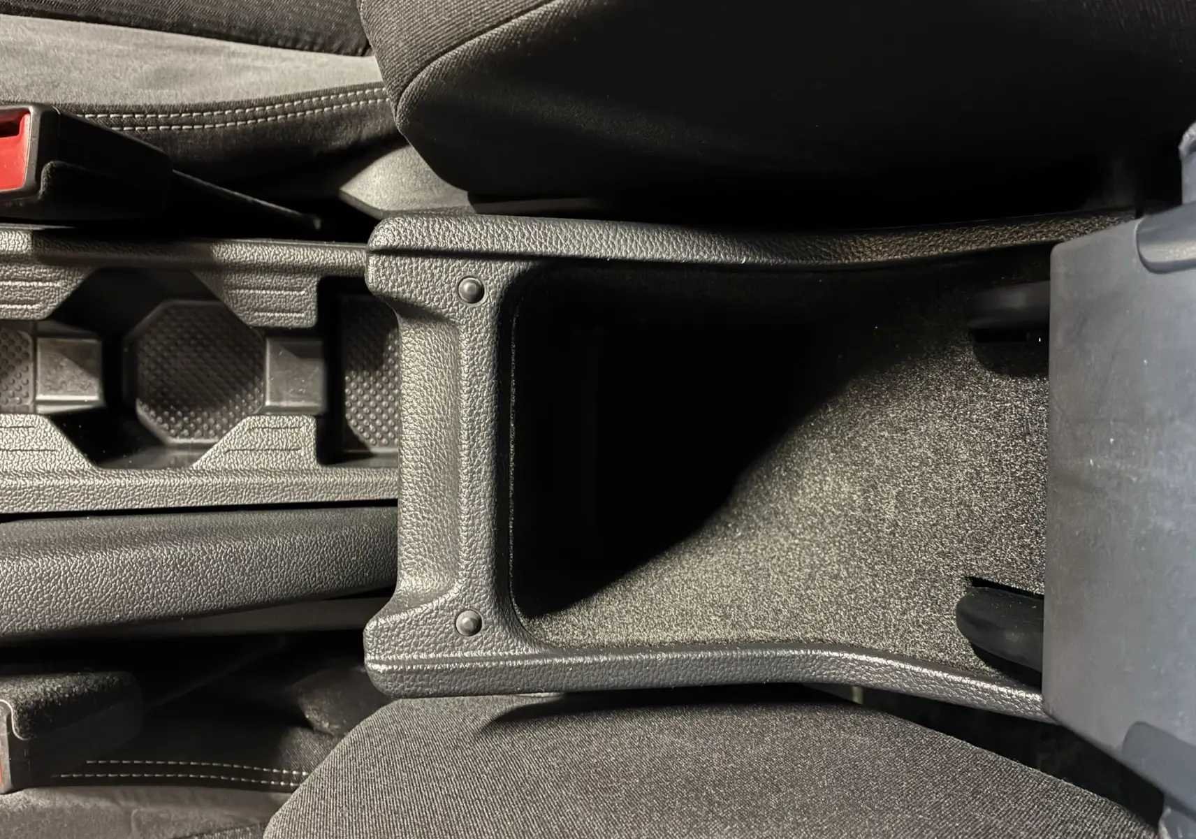 Vue plongeante sur le rangement central noir et les sièges en tissu gris foncé de la Volkswagen Taigo 1.5 TSI 150 R-LINE 2023.