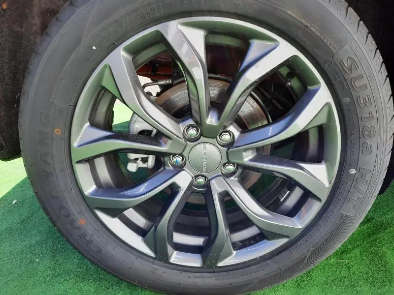 Gros plan sur la jante aluminium noire au design moderne de la roue du SERES 3 rouge carmin électrique.