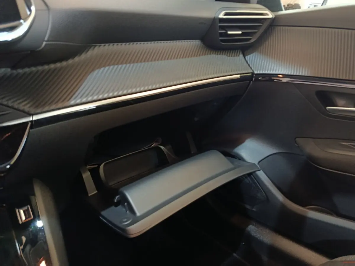 Intérieur Peugeot 208 Electrique blanc 2020, vue côté passager sur boîte à gants ouverte et tableau de bord noir.