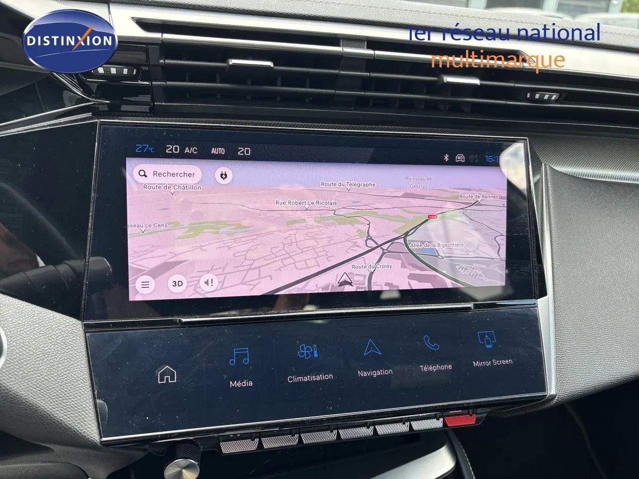 Vue rapprochée de l’écran tactile central du tableau de bord de la Peugeot 308 SW blanche nacrée, affichant la navigation.