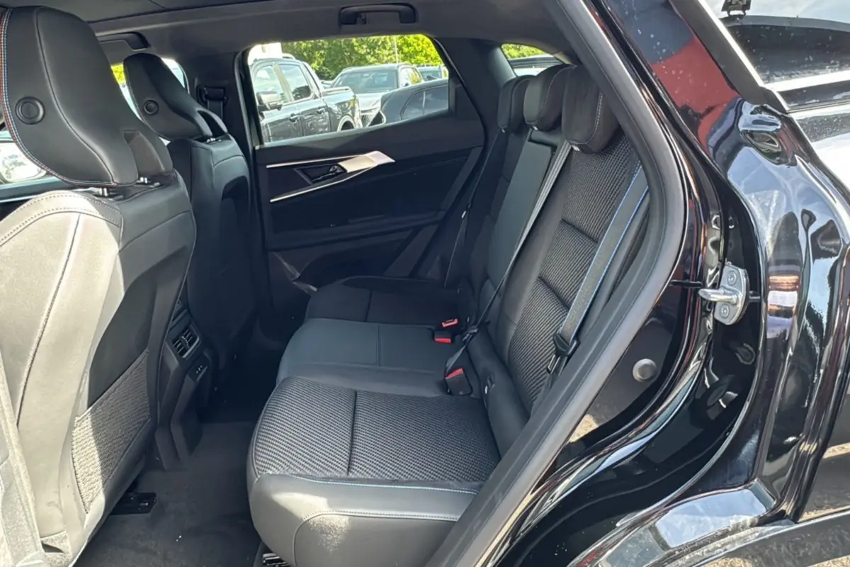 Vue côté droit sur l'intérieur arrière du Renault Austral 2025 noir étoilé, avec sièges en tissu et cuir contrasté.