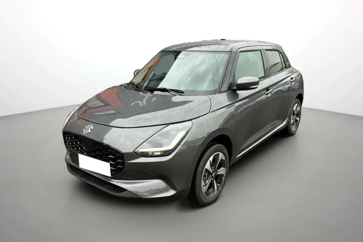 Suzuki Swift 2025 gris minéral vue 3/4 avant droit avec jantes alliage et phares LED allumés.