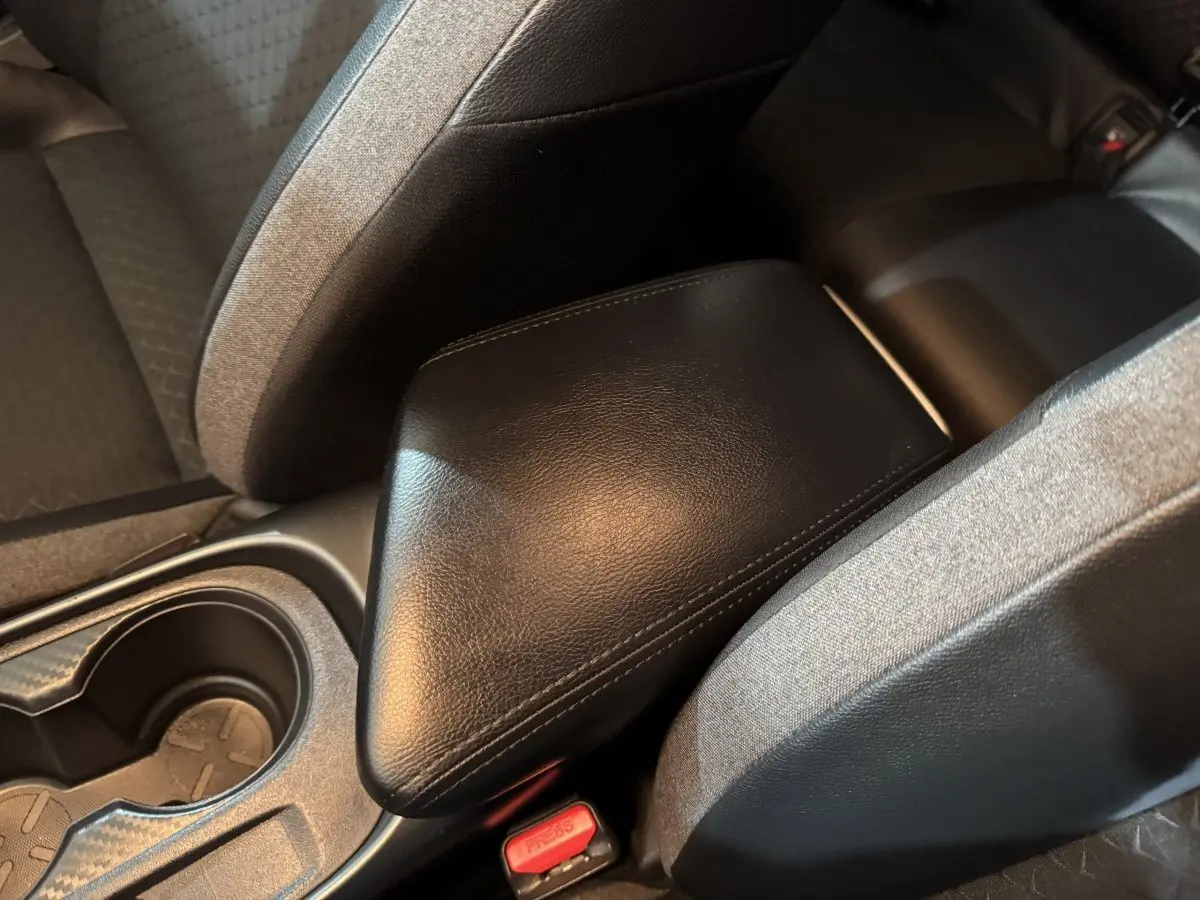 Gros plan sur l'accoudoir central en cuir noir entre les sièges arrière gris foncé du Nissan Juke 2025.