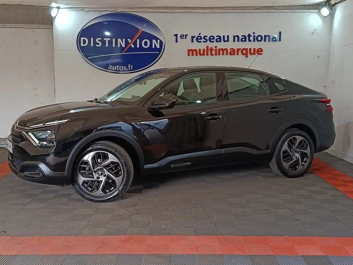 Vue de profil côté gauche d'une Citroën C4 X noire 2023 avec jantes distinctives et lignes fluides.