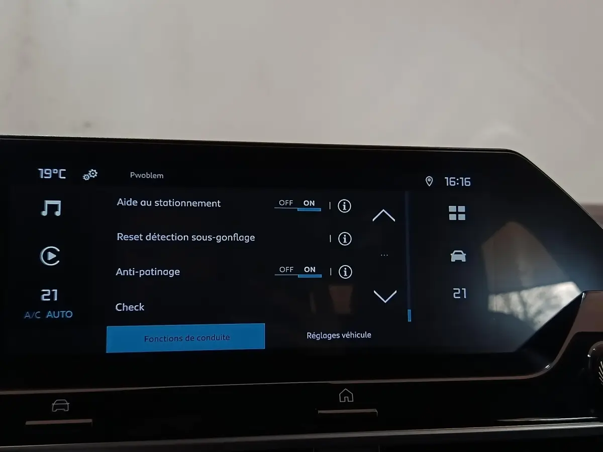 Écran tactile central du tableau de bord de la Citroën C4 X noir, affichant les réglages d’aide au stationnement et d’anti-patinage.