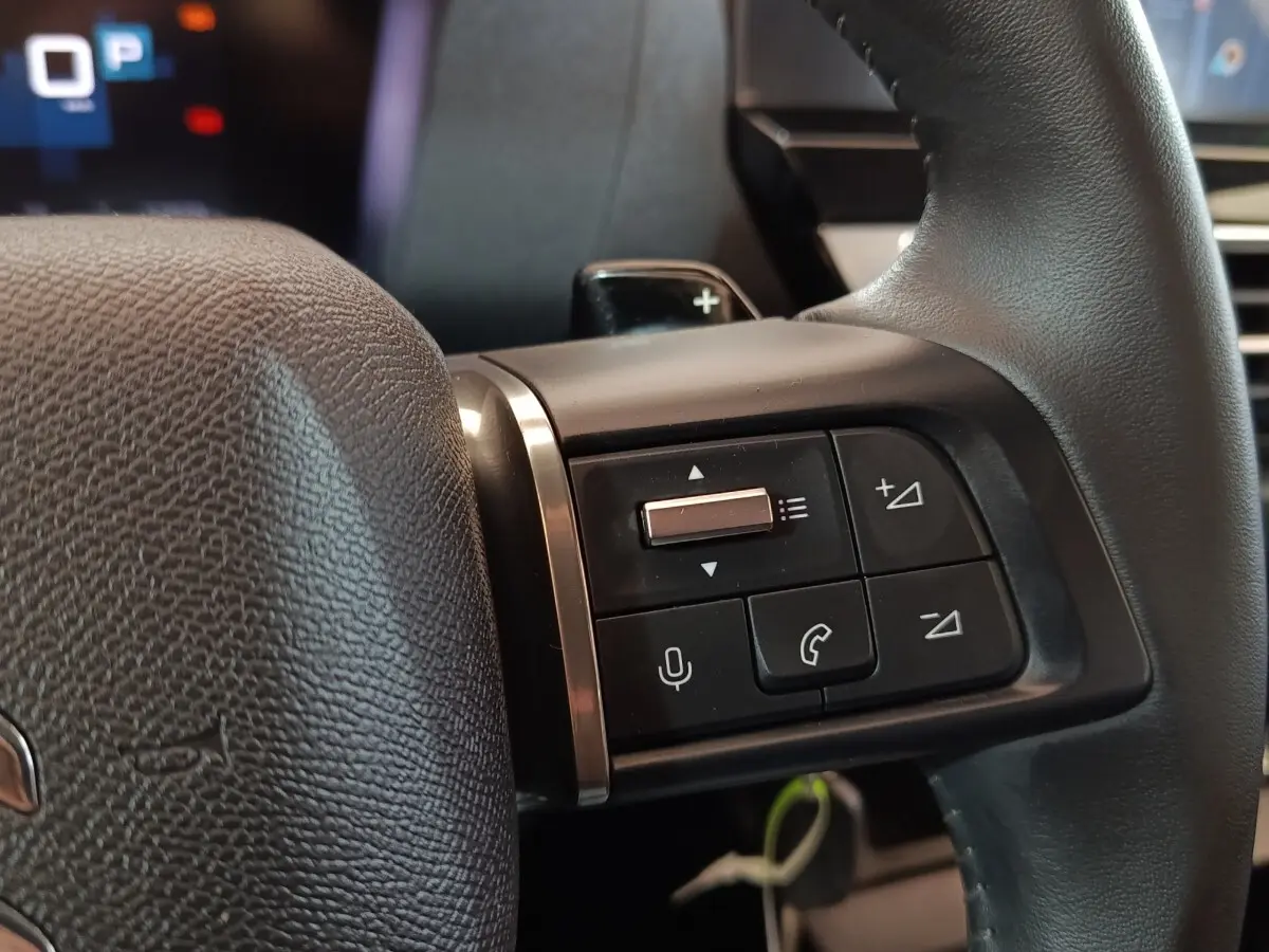 Gros plan sur les commandes au volant cuir noir du Citroën C4 X 2023, avec boutons multifonctions et palettes de changement.