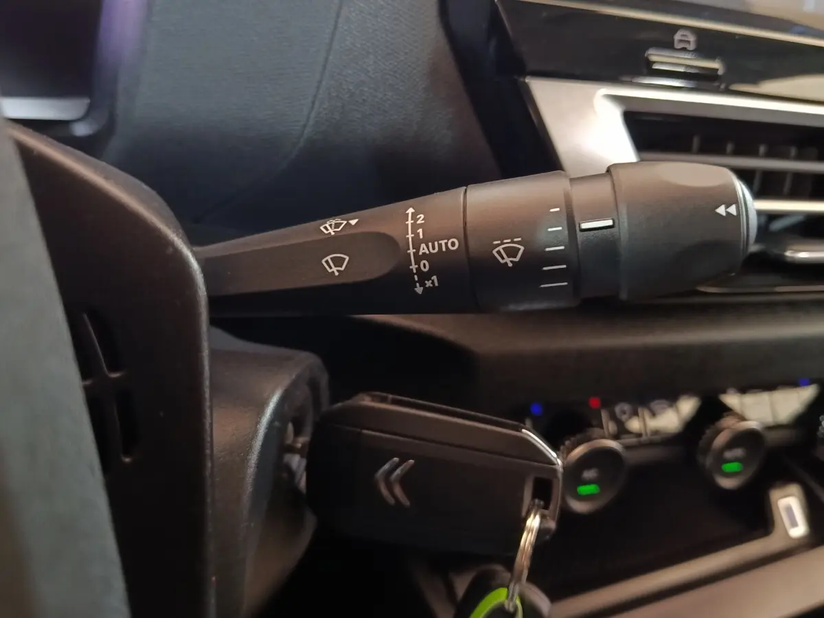 Gros plan sur la commande d’essuie-glace et la clé noire du tableau de bord intérieur d’une Citroën C4 X 2023.