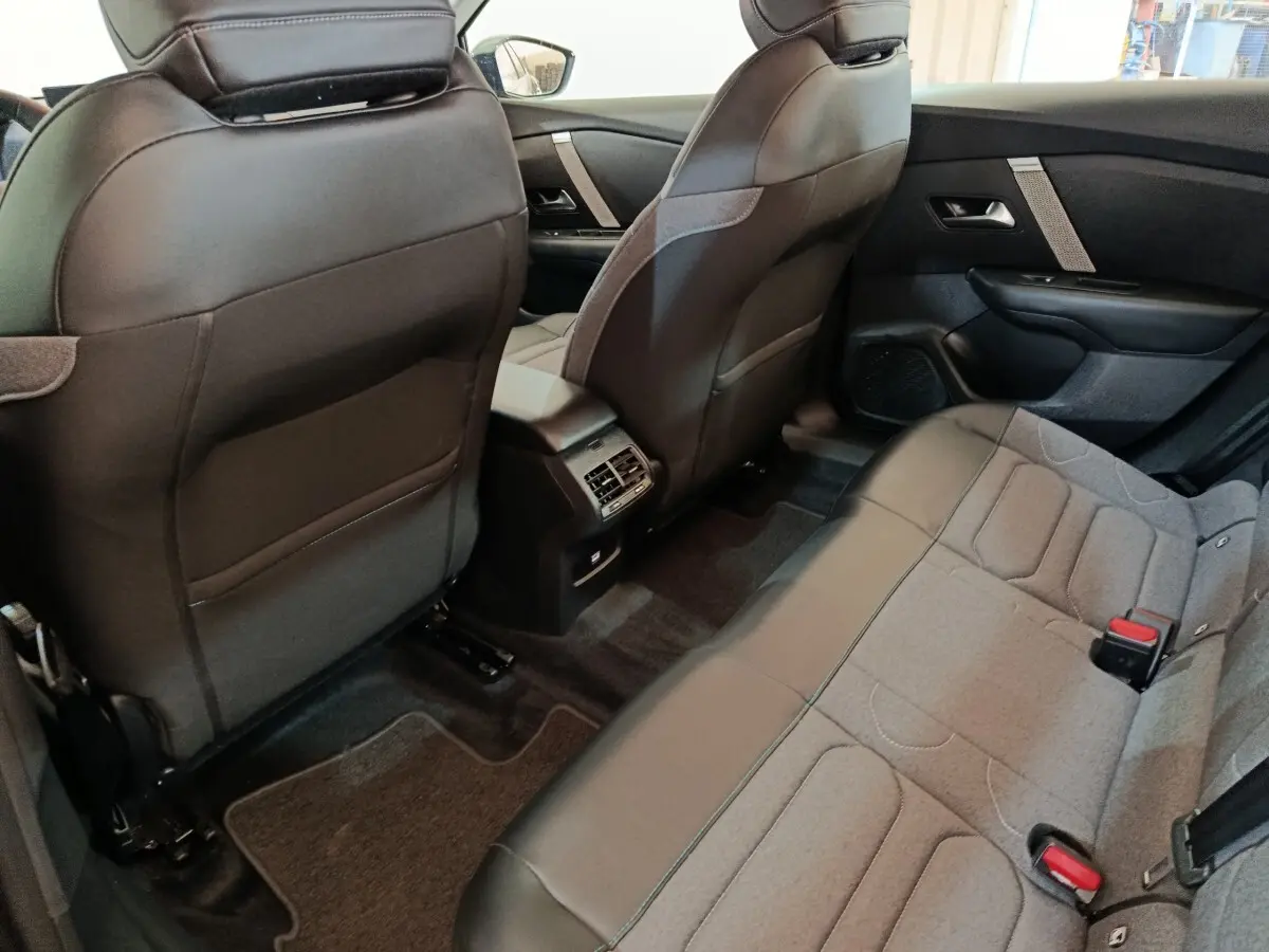 Vue intérieure arrière côté droit de la Citroën C4 X noire, montrant les sièges arrière et la console centrale avec aérateurs.