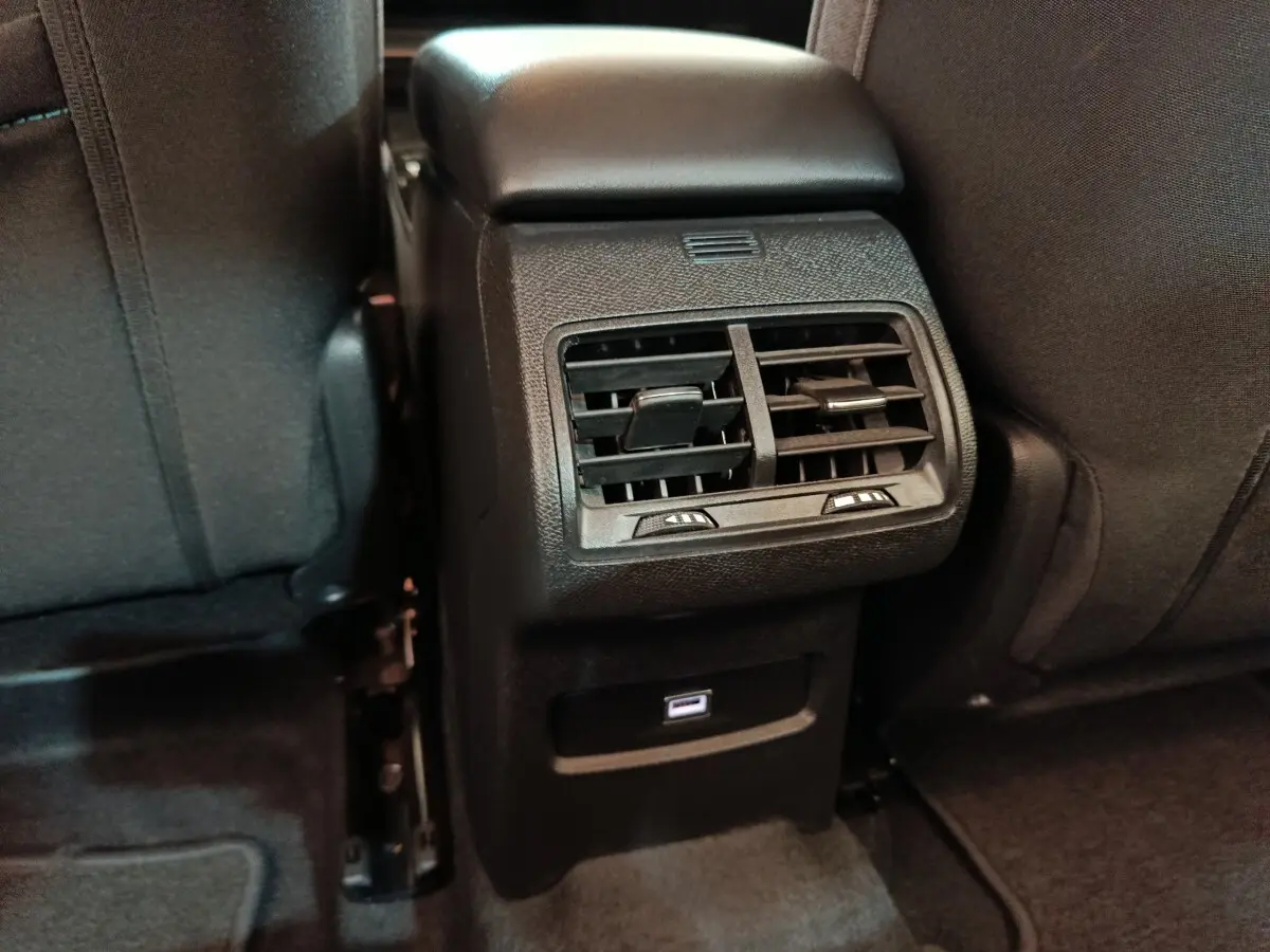 Vue rapprochée des aérateurs arrière et port USB sur la console centrale noire de la Citroën C4 X 2023.