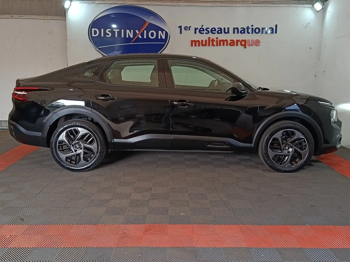 Profil droit d'une Citroën C4 X noire 2023 avec jantes alliage et feux arrière LED distinctifs.