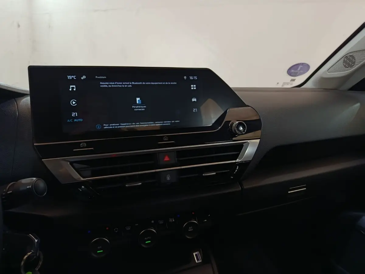 Vue intérieure du tableau de bord de la Citroën C4 X 2023 avec écran tactile central et commandes climatisation.
