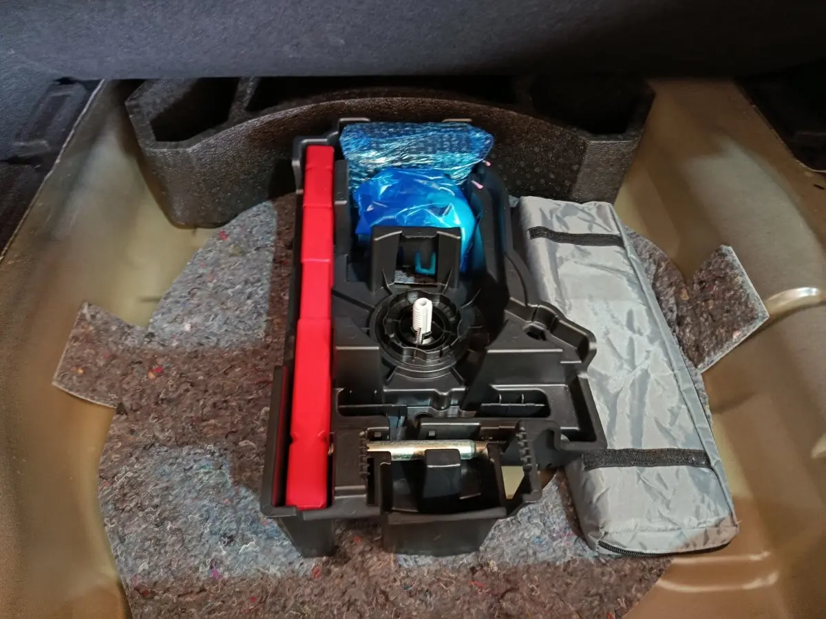 Rangement sous coffre de la Citroën C4 X 2023, contenant outils et accessoires de sécurité.