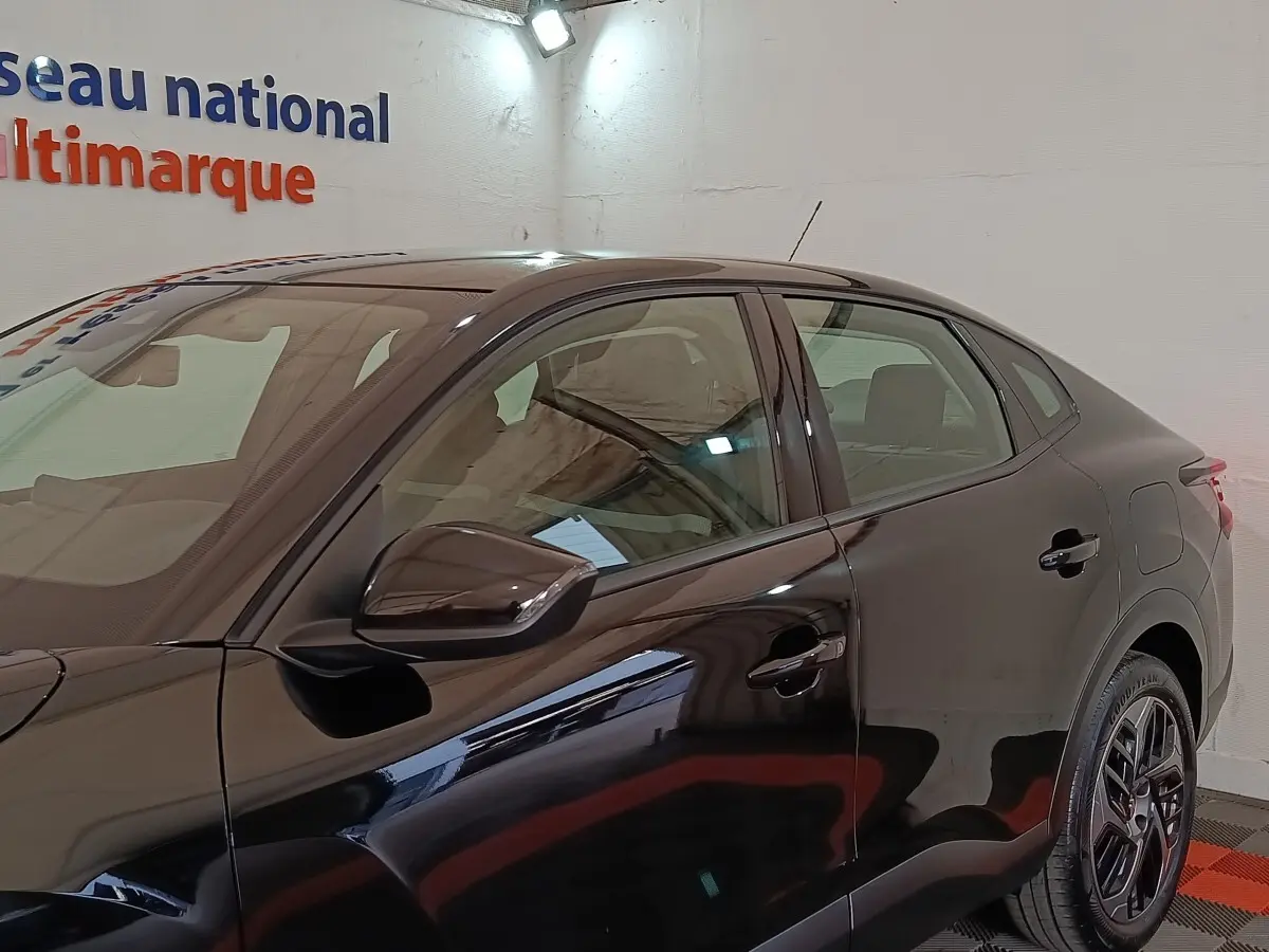 Vue latérale gauche du Citroën C4 X noir 2023, mettant en valeur ses lignes fluides et ses jantes distinctives.