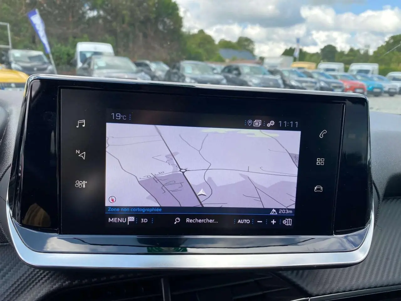 Écran tactile 7 pouces affichant la navigation 3D dans l'habitacle de la Peugeot 208 noire, vue de face.