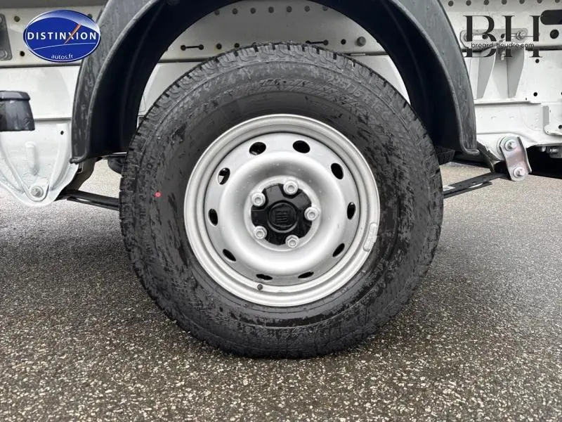 Gros plan sur la roue arrière droite du FIAT Ducato Benne blanc 2023 avec jante acier et pneu tout-terrain.