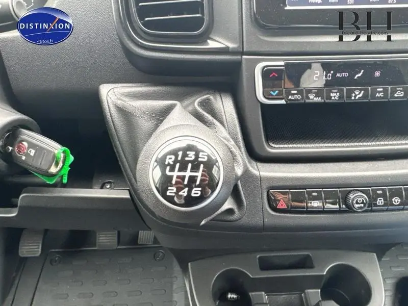 Gros plan sur le levier de vitesses manuel du Fiat Ducato Benne 2023, tableau de bord noir avec climatisation automatique visible.