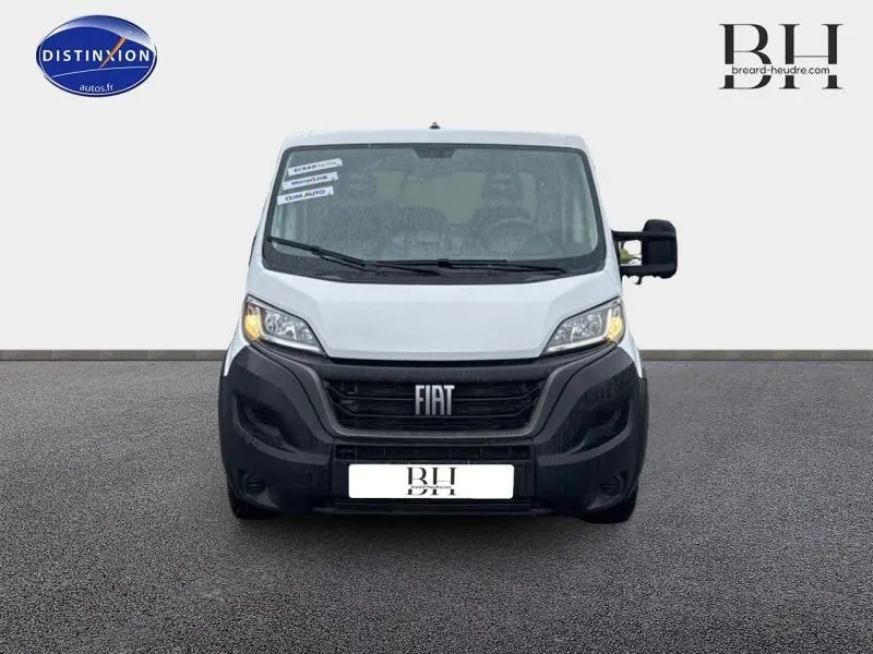 Vue de face d'un FIAT Ducato Benne blanc 2023 avec calandre noire et phares allumés sur fond neutre.