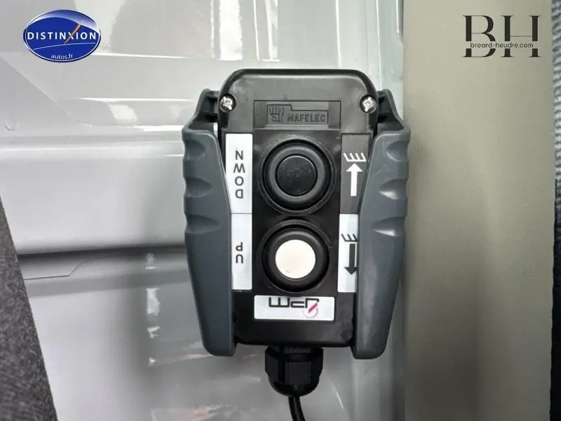 Gros plan sur la commande de benne acier du FIAT Ducato Benne blanc, avec boutons de montée et descente visibles.