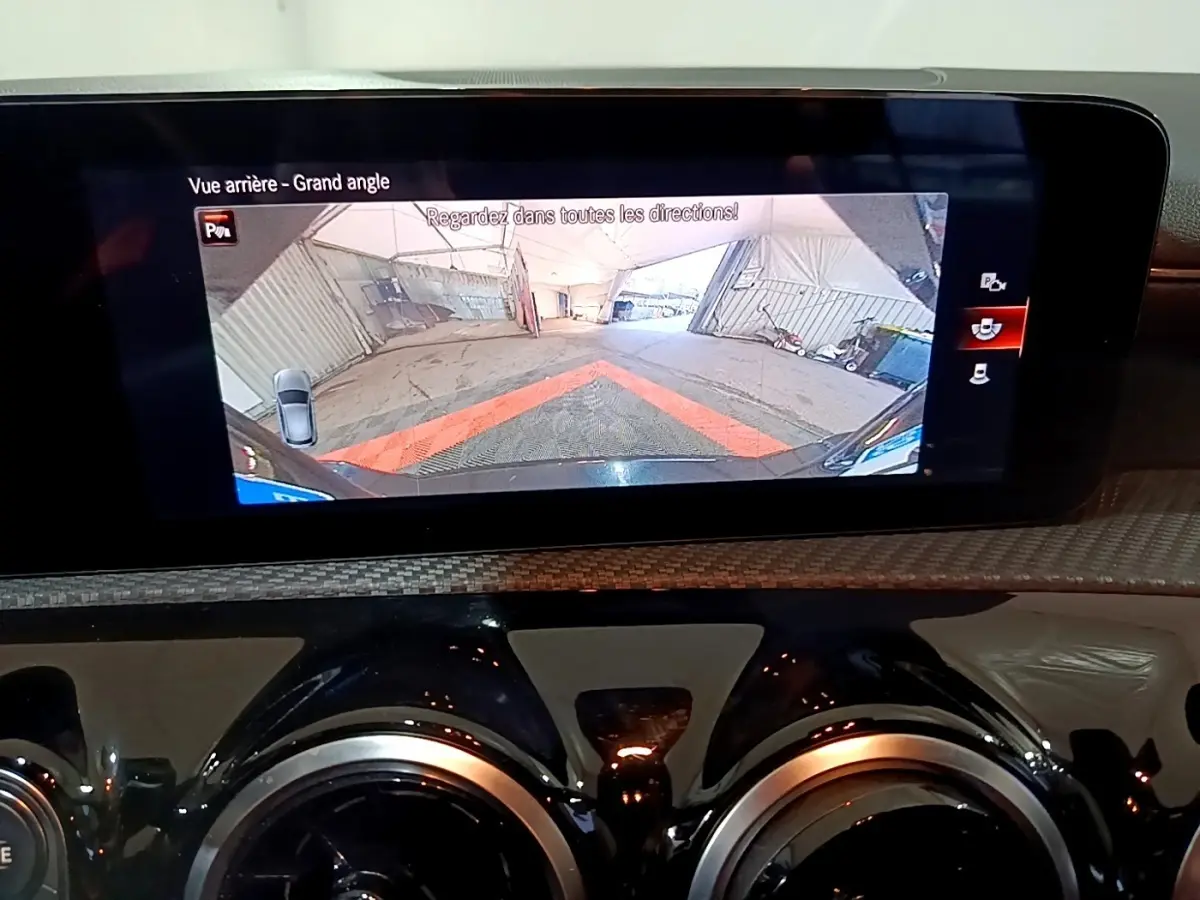 Écran tactile intérieur affichant la caméra de recul grand angle d'une Mercedes Classe A noire, vue arrière.