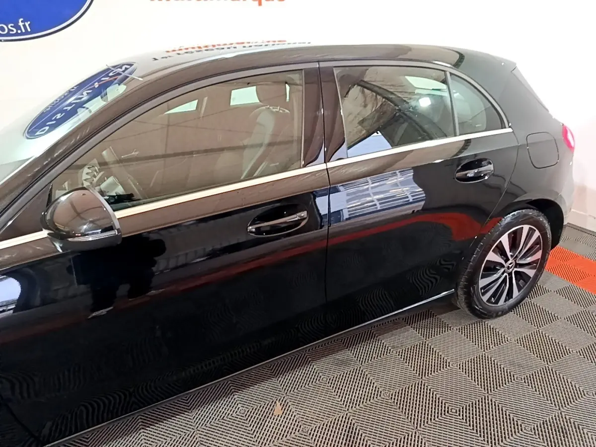 Vue latérale côté gauche d'une Mercedes Classe A noire avec jantes alliage et poignées de porte chromées.