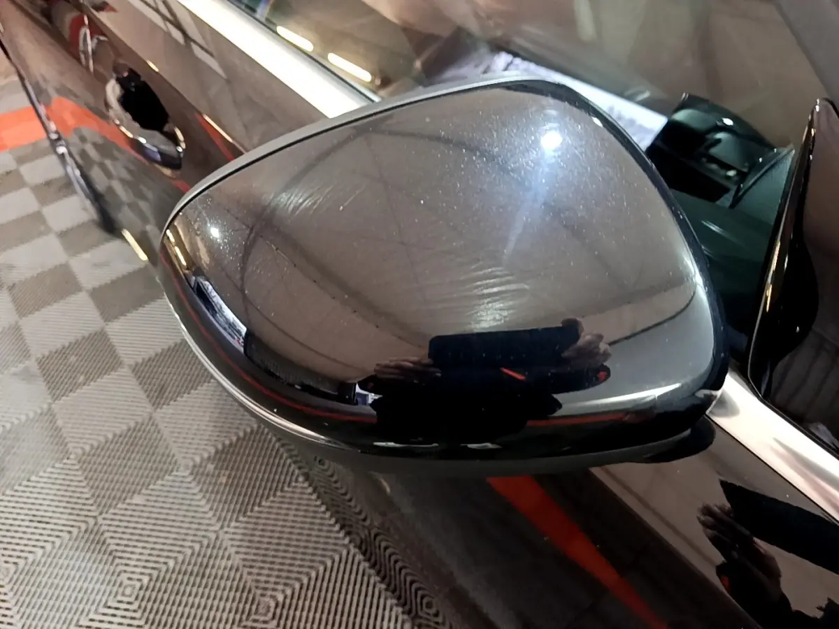 Gros plan sur le rétroviseur côté droit noir brillant d’une Mercedes Classe A 250 e Business Line 2020.