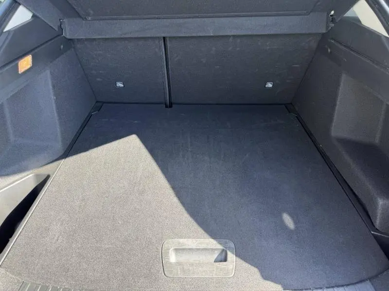 Vue plongeante sur le coffre spacieux et propre du Renault Arkana 2025 gris métallisé, sans chargement visible.