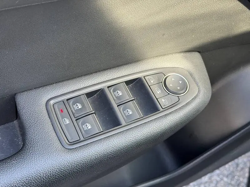 Gros plan sur les commandes des vitres électriques et rétroviseurs du côté conducteur d’un Renault Arkana gris métallisé 2025.