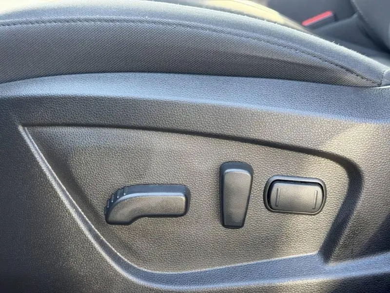 Détail des commandes de réglage électrique du siège côté gauche dans un Renault Arkana gris métallisé 2025.