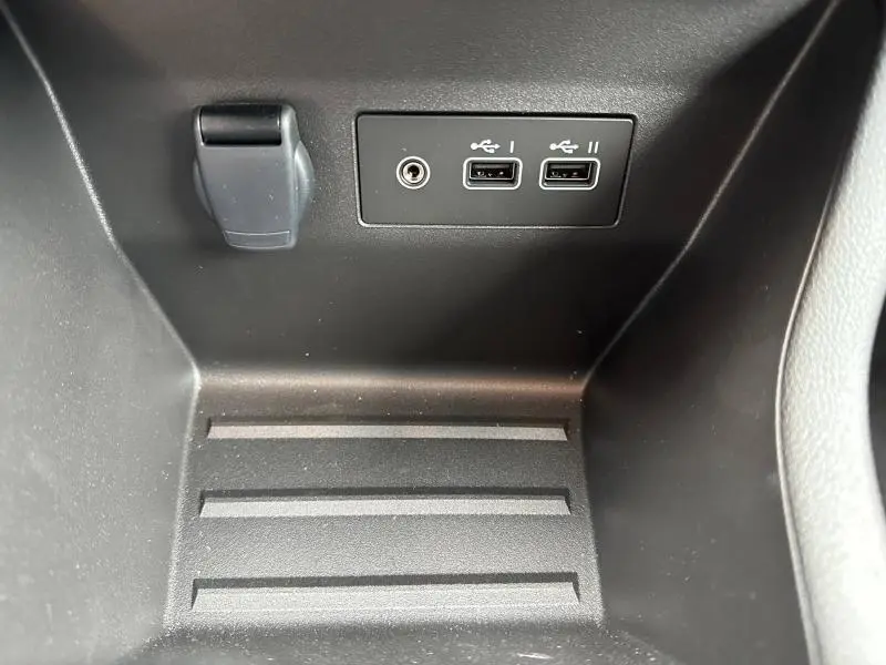 Gros plan sur la console centrale de la Renault Clio 2025 gris Rafale montrant prises USB et prise auxiliaire.