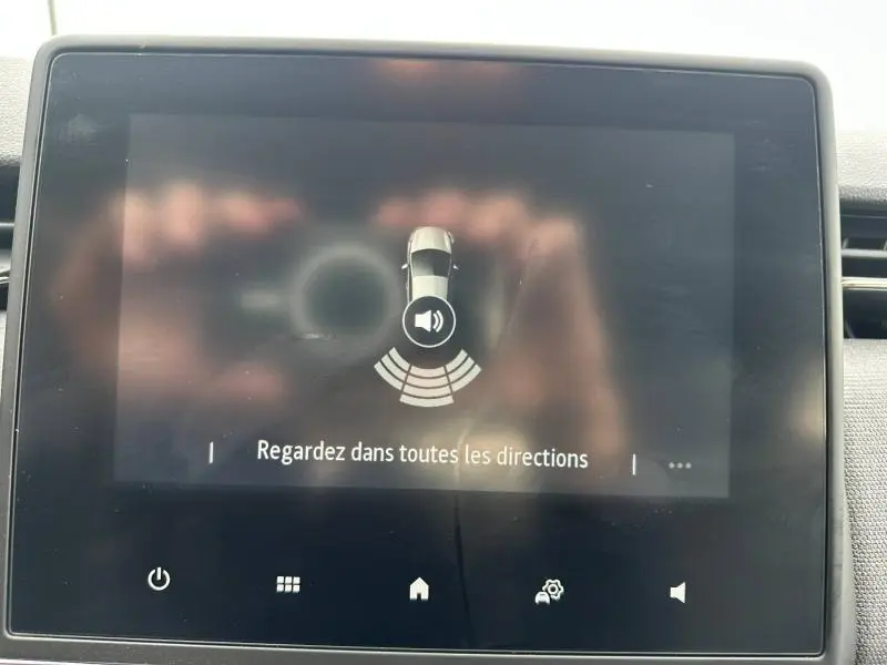 Écran tactile intérieur de la Renault Clio 2025 affichant l'alerte de détection d'obstacles en mode assistance au stationnement.