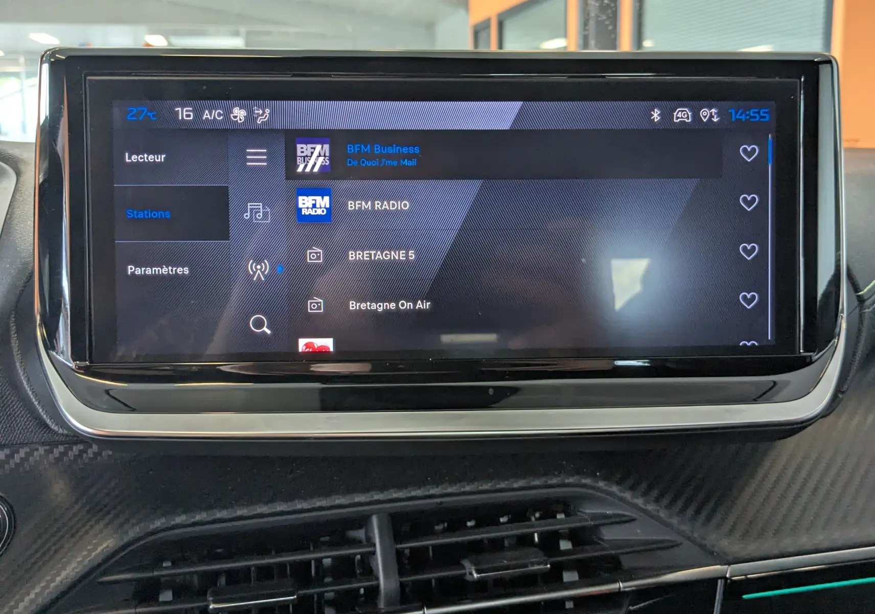 Écran tactile central du tableau de bord de la Peugeot 208 Hybrid 145, affichant les stations radio.
