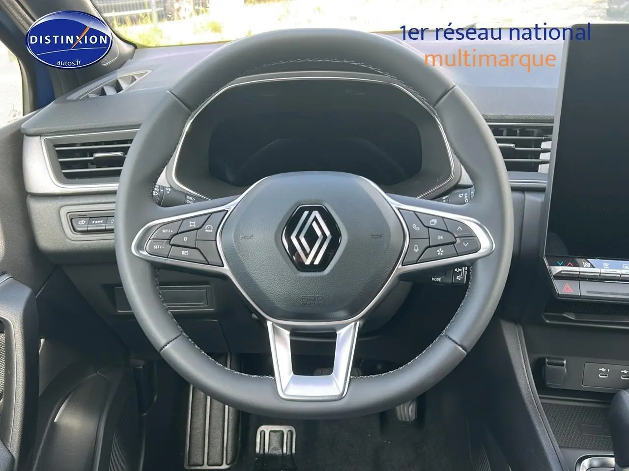 Vue intérieure centrée sur le volant multifonction noir du Renault Captur 2025 avec tableau de bord et écran tactile visible.