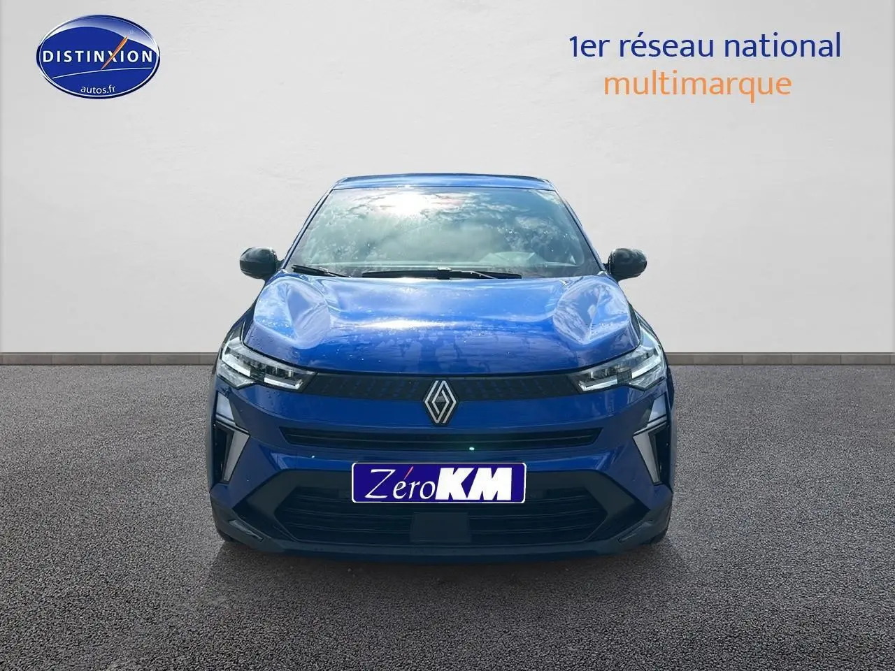 Vue frontale d'un Renault Captur 1.6 e-tech hybride 145 techno bleu iron avec logo Renault bien visible sur calandre.
