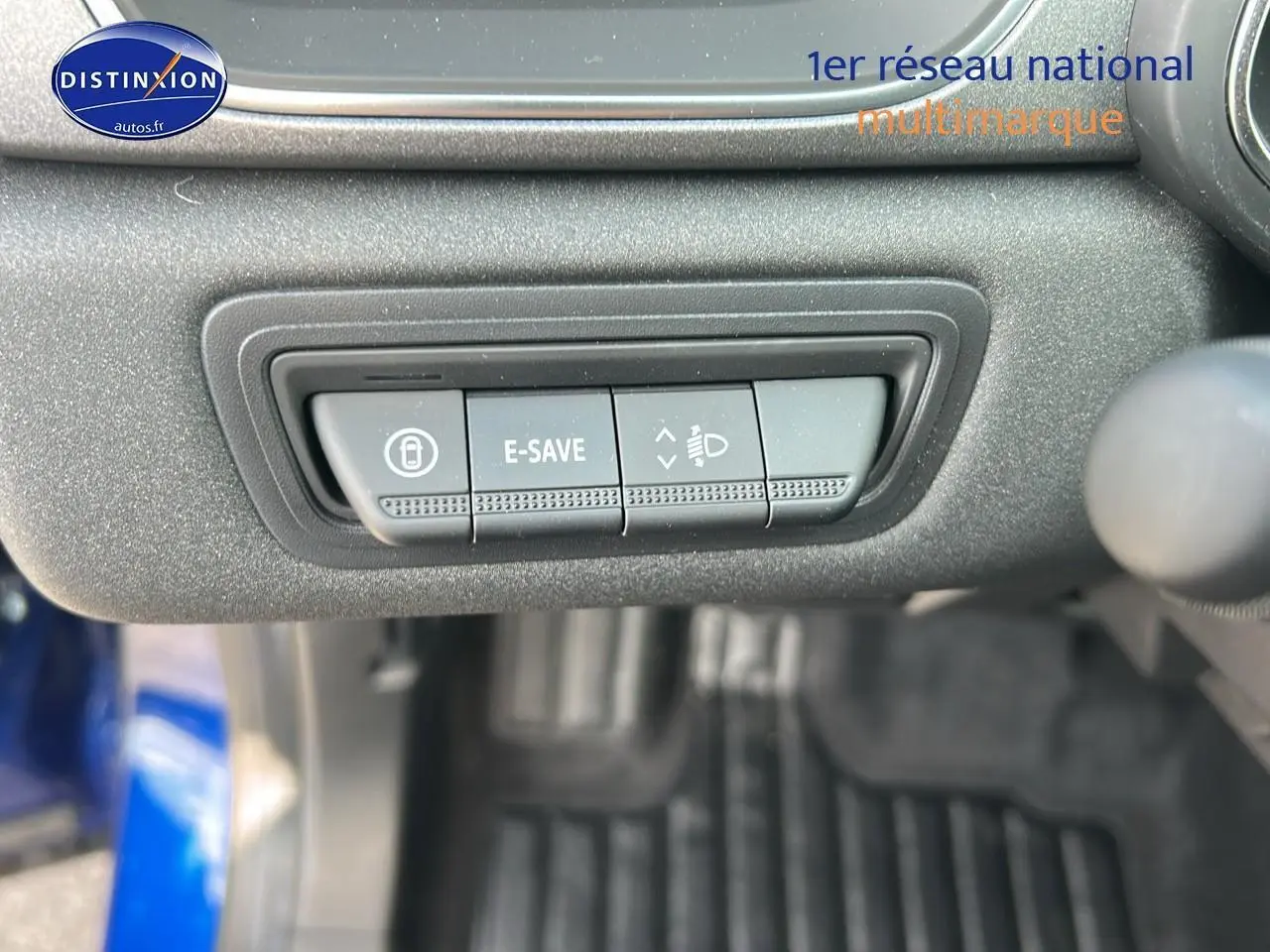 Gros plan sur les commandes E-SAVE et réglage des phares dans l'habitacle d'un Renault Captur Bleu Iron 2025.