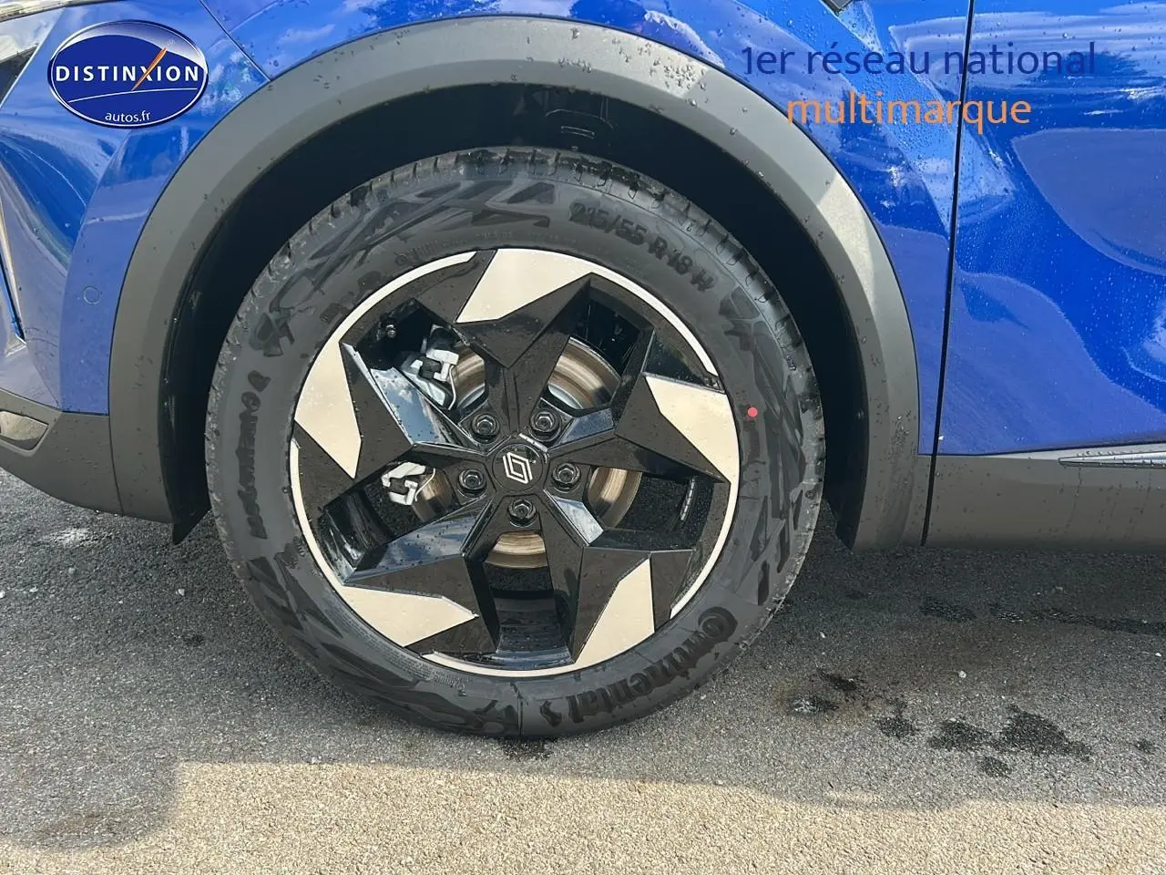 Gros plan sur la roue avant gauche avec jante alu noire et argent du Renault Captur bleu iron 2025.