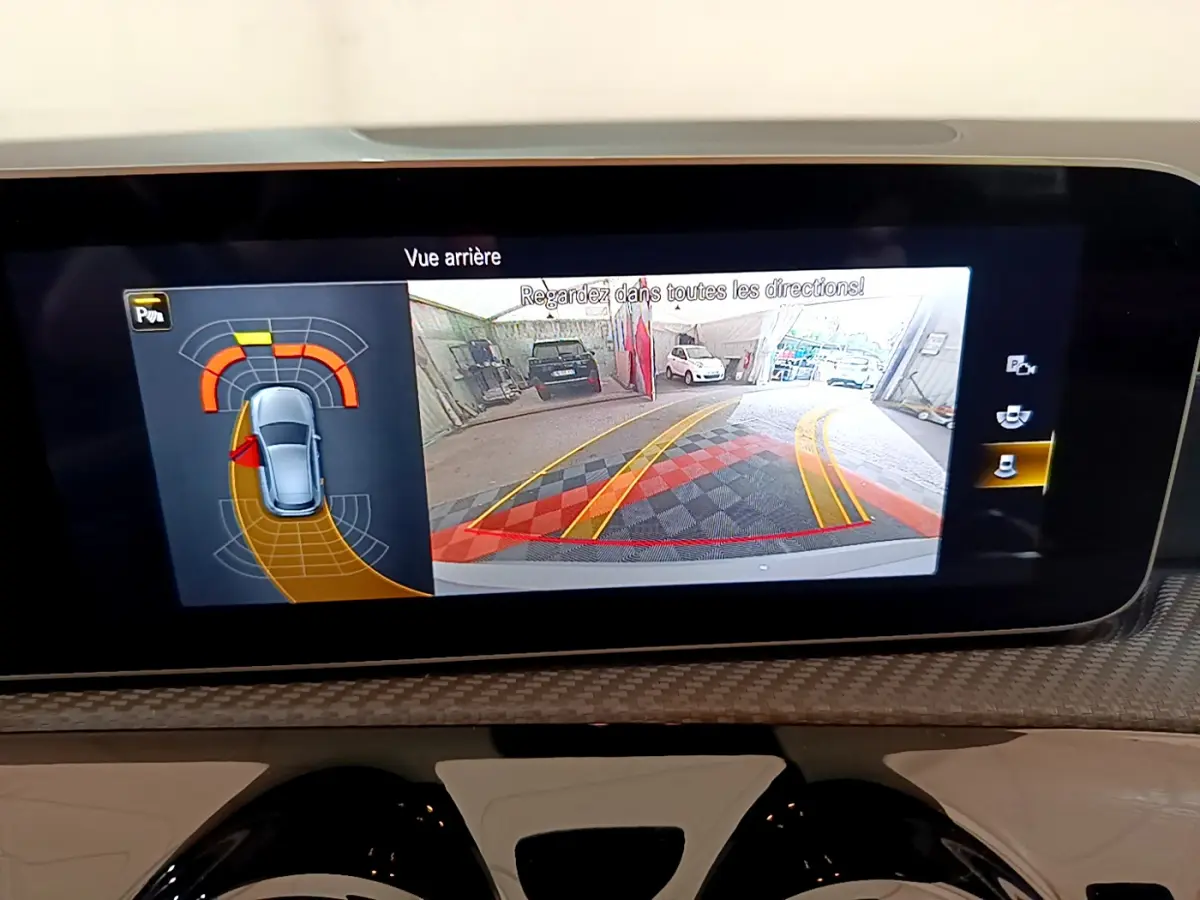 Écran tactile intérieur montrant la caméra de recul et l’aide au stationnement de la Mercedes Classe A gris clair.