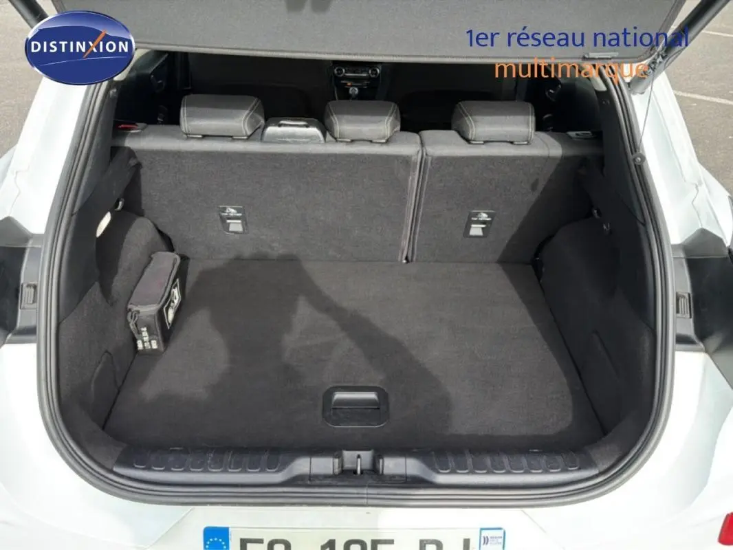 Coffre ouvert vu de l'arrière d'un Ford Puma blanc 2020, montrant l'espace de chargement et les sièges arrière rabattables.