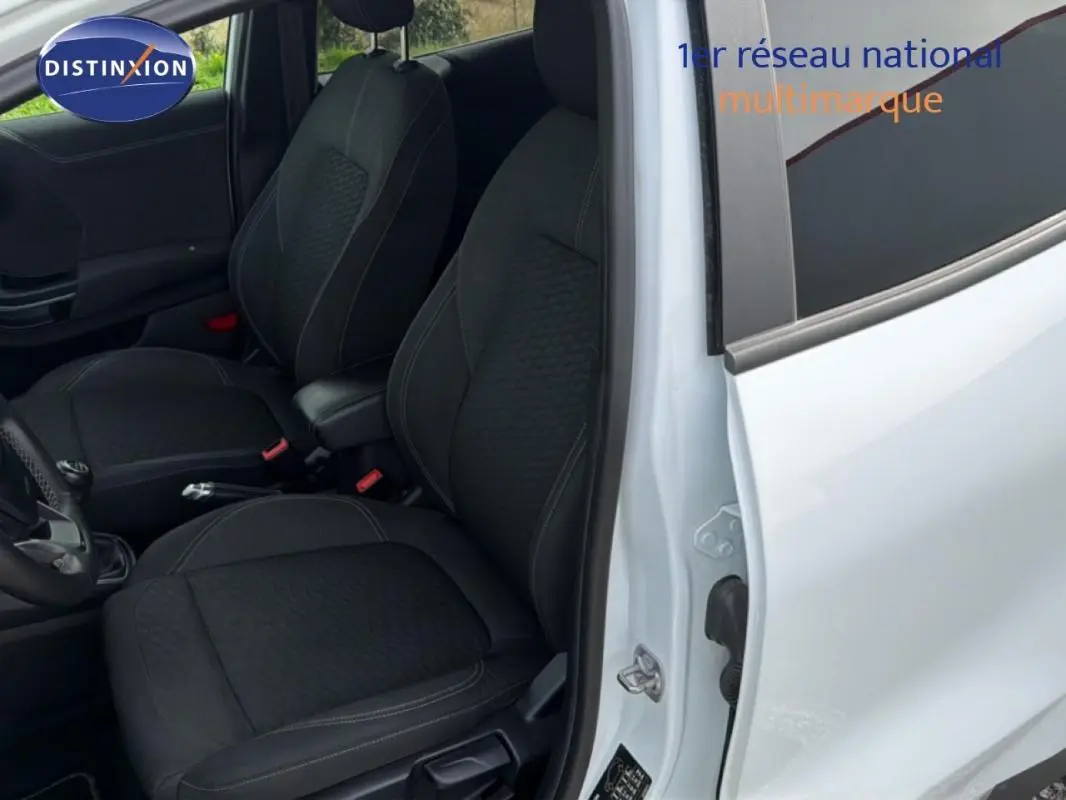 Vue intérieure côté conducteur d'un Ford Puma blanc 2020, sièges sport noirs et vitres surteintées.