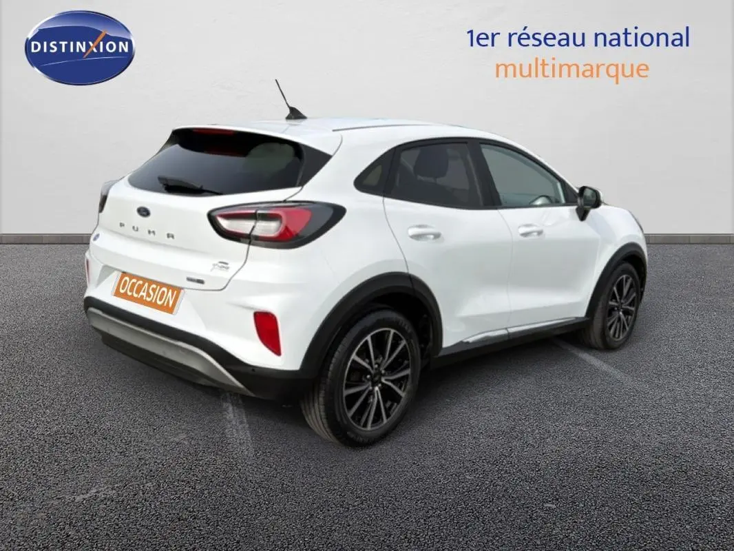 Vue 3/4 arrière droite d’un Ford Puma blanc avec jantes alliage noires et vitres surteintées.