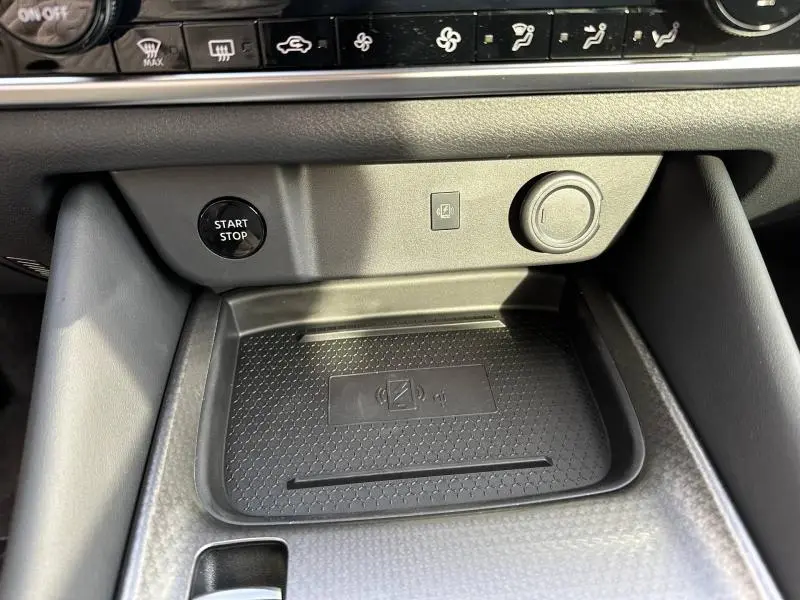 Détail intérieur du Nissan Qashqai Hybrid e-POWER 2025 montrant la zone de recharge sans fil et le bouton Start/Stop.