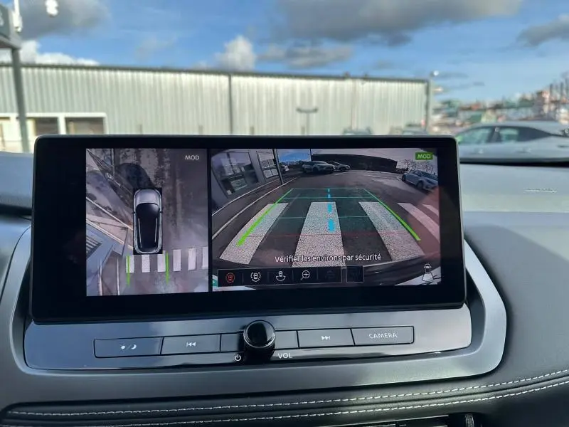Écran central du Nissan Qashqai Hybrid e-POWER 2025 montrant la caméra de recul avec vue arrière et vue aérienne du véhicule noir.