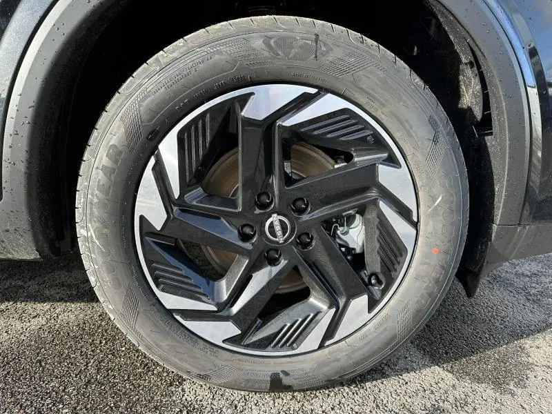 Gros plan sur la roue avant gauche du Nissan Qashqai Hybrid e-POWER 2025 avec jante noire et argentée au design moderne.