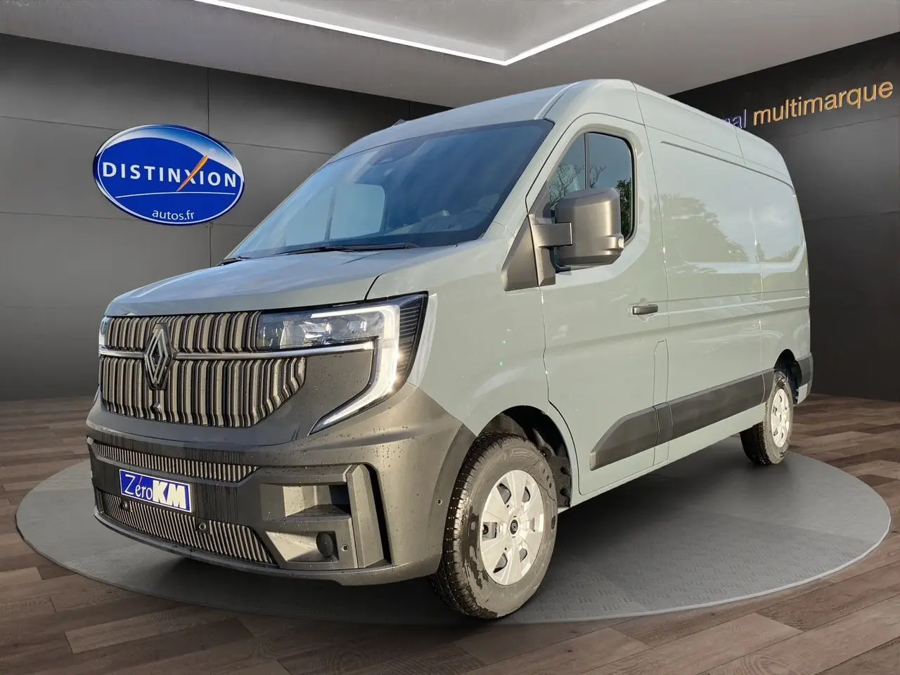 Renault Master gris urbain en 3/4 avant droit, avec calandre noire distinctive et roues blanches.