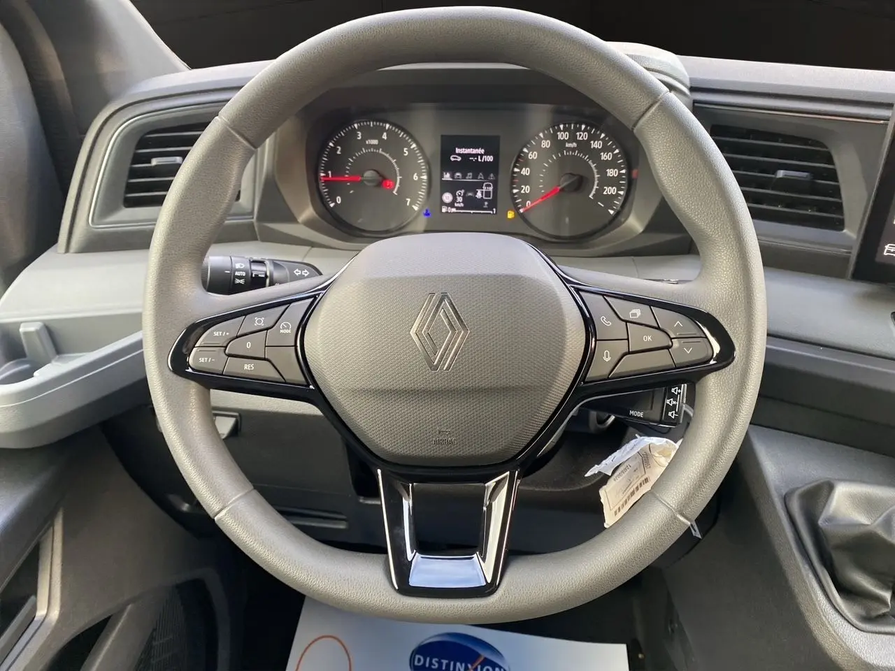 Vue rapprochée du volant gris avec commandes intégrées et tableau de bord du Renault Master 2025.