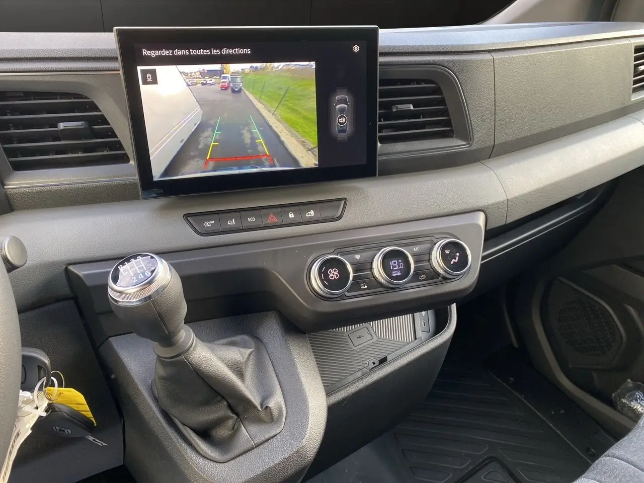 Vue intérieure du tableau de bord du Renault Master 2025 avec écran de caméra de recul et levier de vitesse manuel.