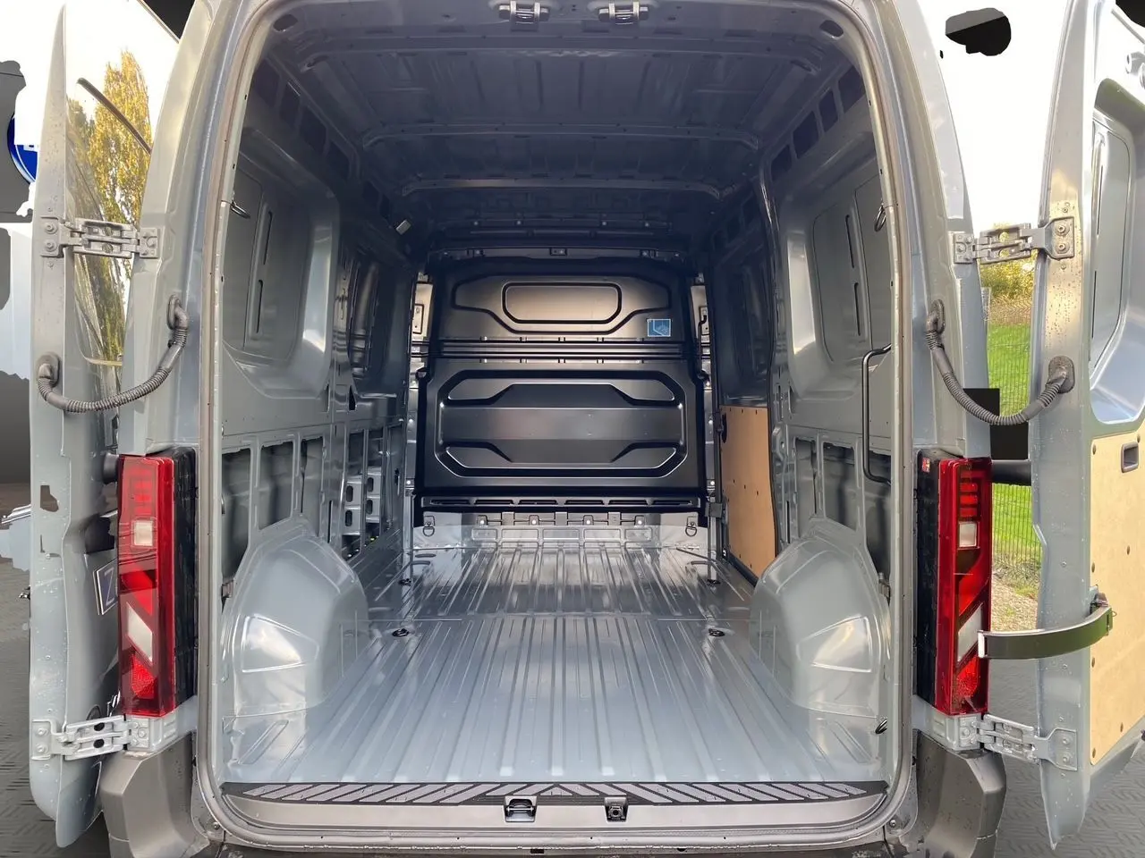 Vue arrière ouverte du Renault Master gris urbain 2025 montrant l'espace de chargement tôlé et le plancher métallique.