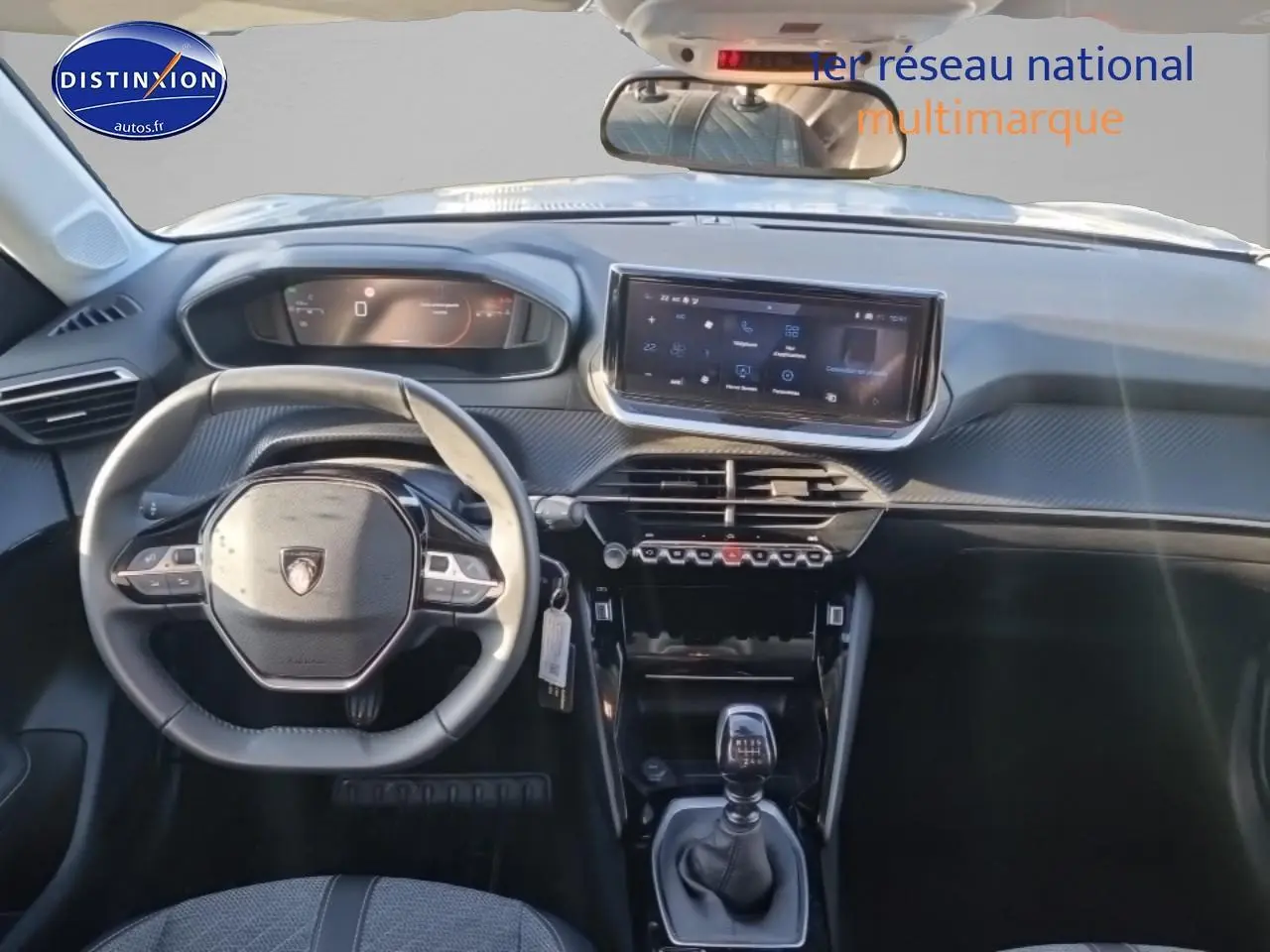 Vue intérieure avant du tableau de bord et volant noir de la Peugeot 208 1.2 100 allure essence 2025.