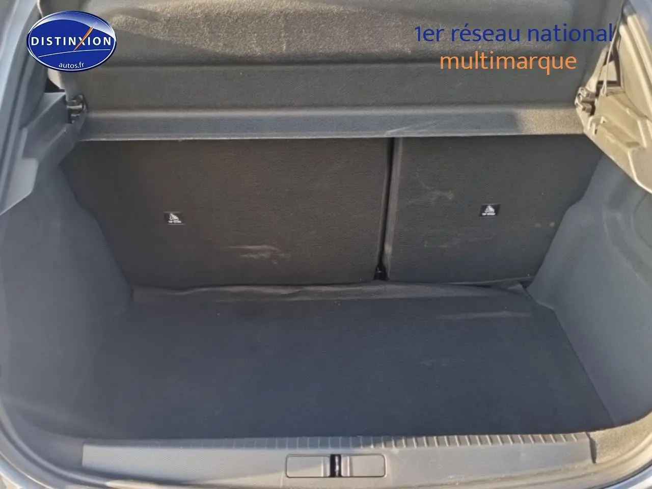 Coffre ouvert de la Peugeot 208 1.2 100 Allure gris Artense, montrant l’espace de rangement arrière vide.