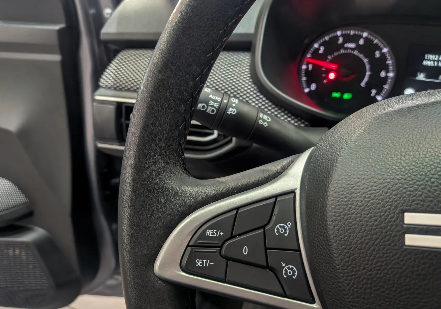 Gros plan sur le volant de la Dacia Sandero TCe 90 CH Journey 2025, montrant les commandes de régulateur de vitesse.